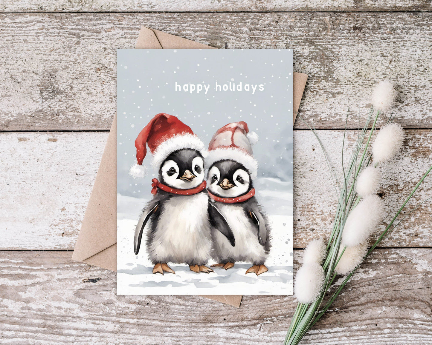 Two Cute baby penguins on a Christmas card with Santa hats wishing you Happy holidays