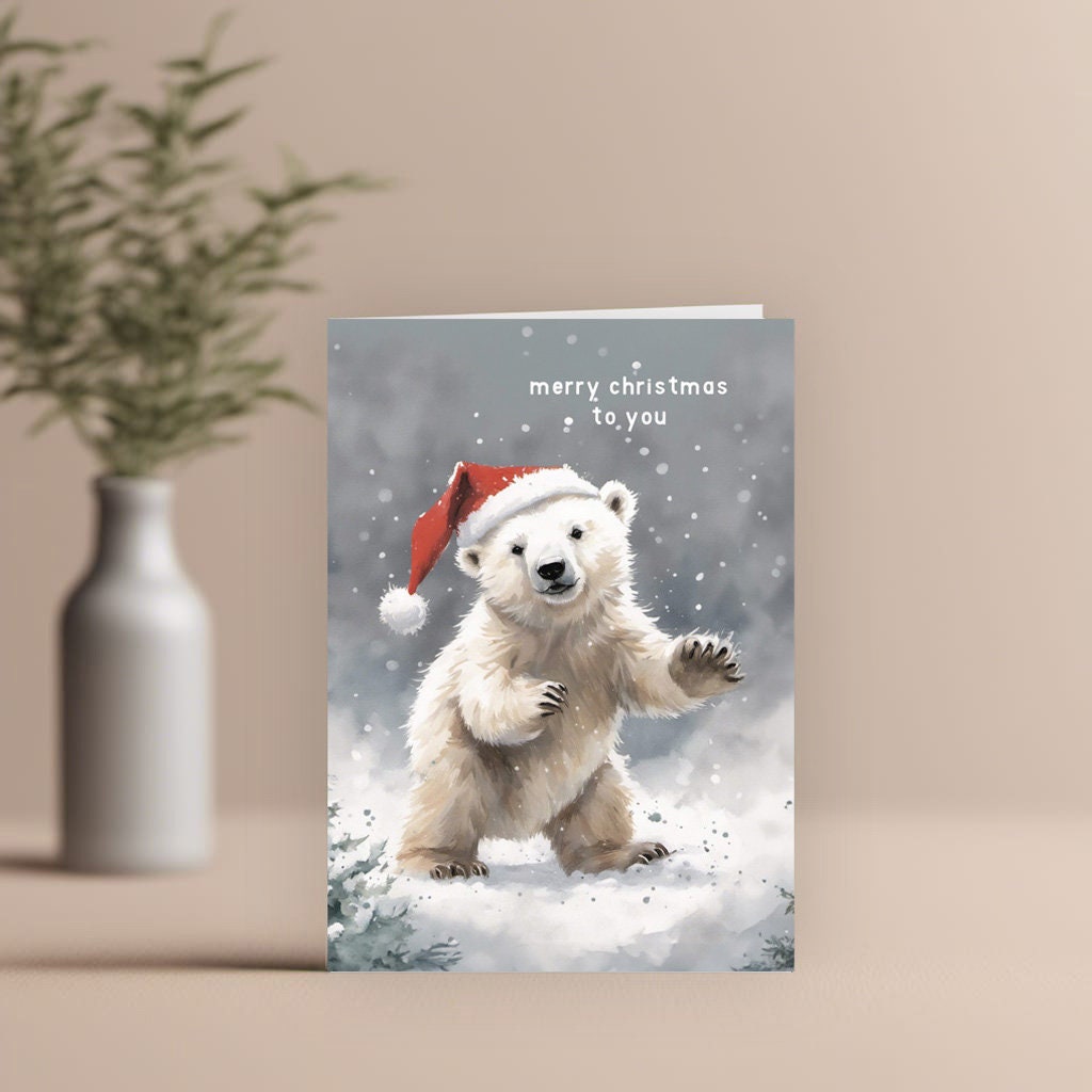 Cute Polar Bear on a Christmas card with Santa hat wishing you a Merry Christmas