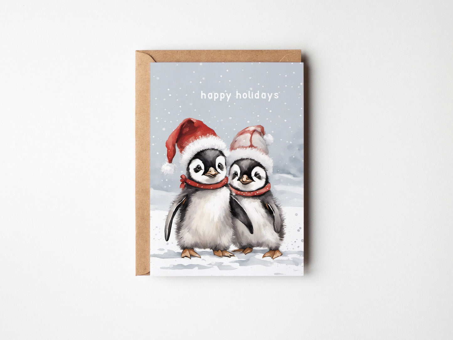 Two Cute baby penguins on a Christmas card with Santa hats wishing you Happy holidays