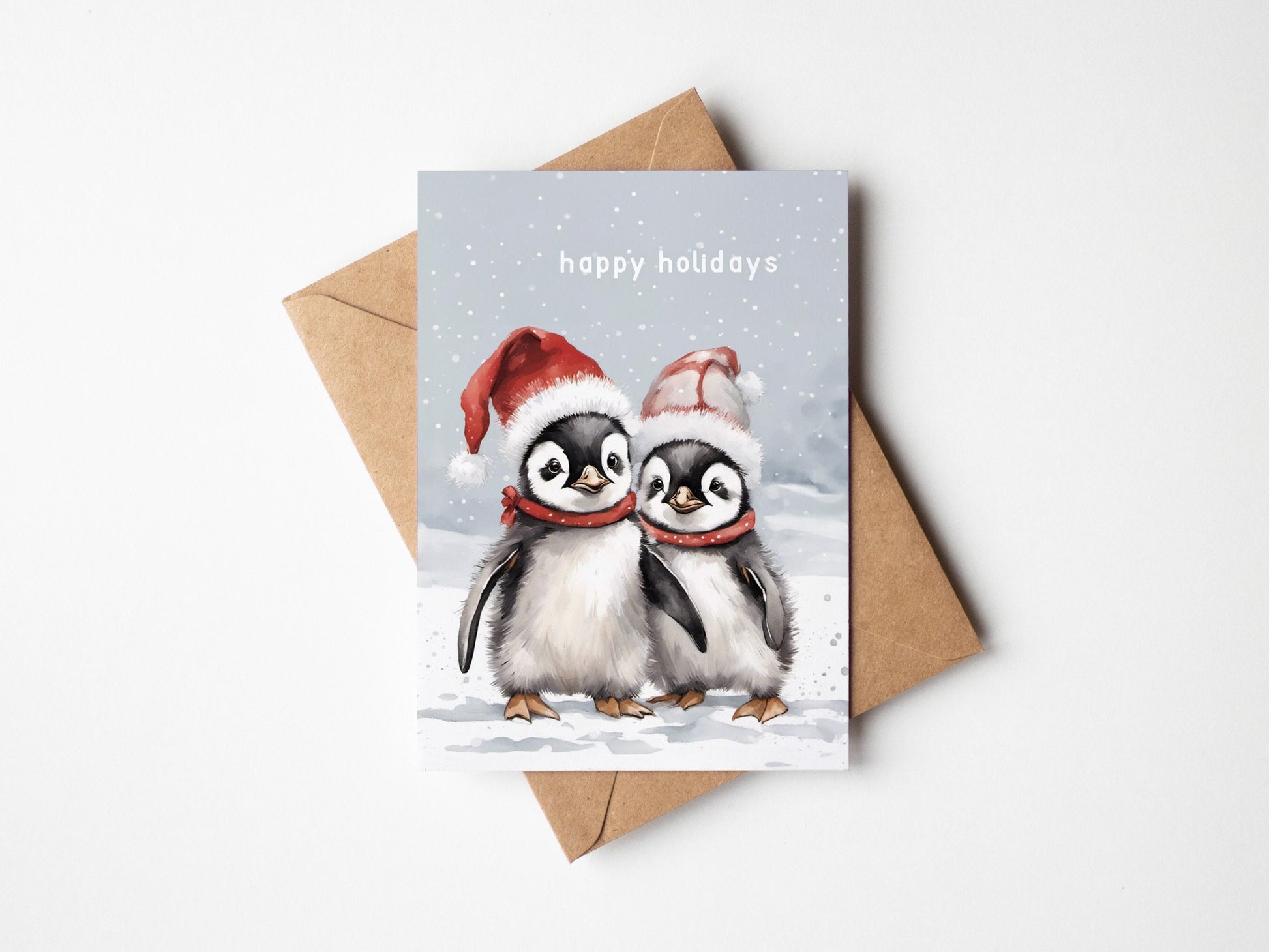 Two Cute baby penguins on a Christmas card with Santa hats wishing you Happy holidays